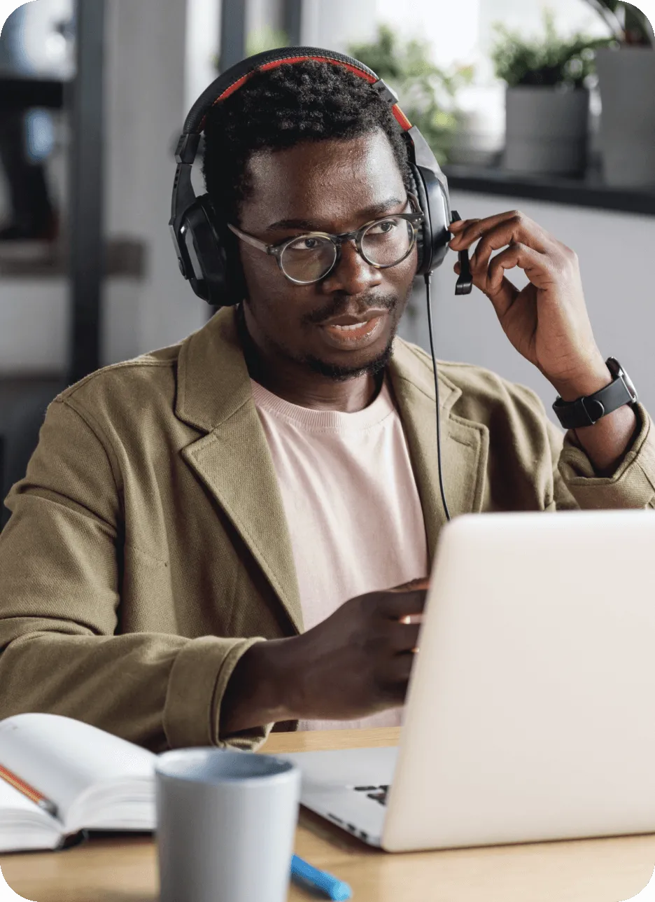 Un employé avec un casque face à un ordinateur portable