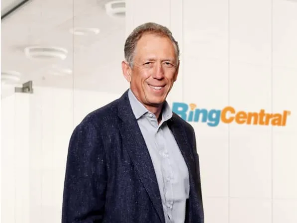 Le PDG de RingCentral, Vlad Shmunis, devant un mur avec le logo de RingCentral.